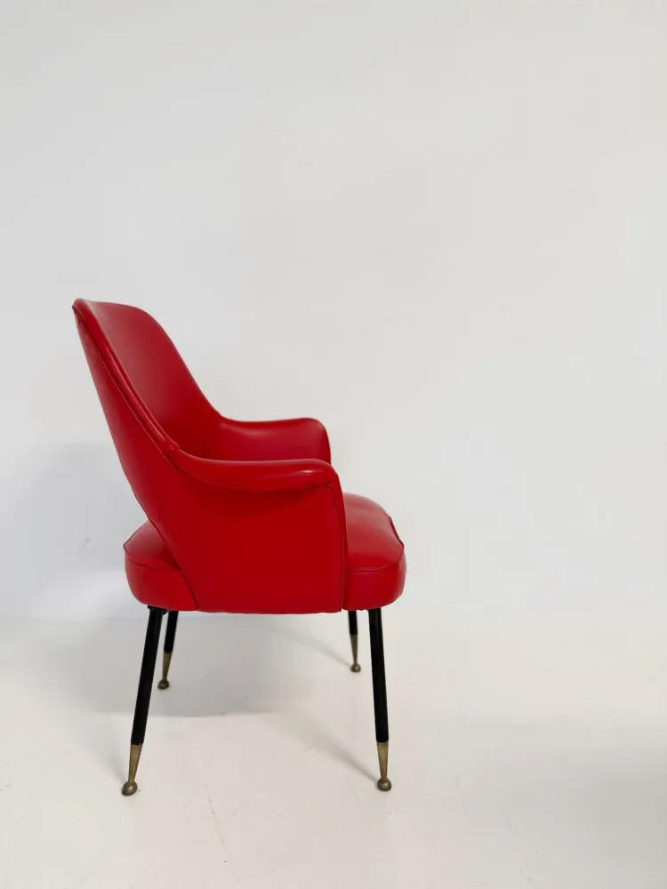 Poltrona italiana anni ’50 skai rosso, con schienale sagomato e apertura posteriore.