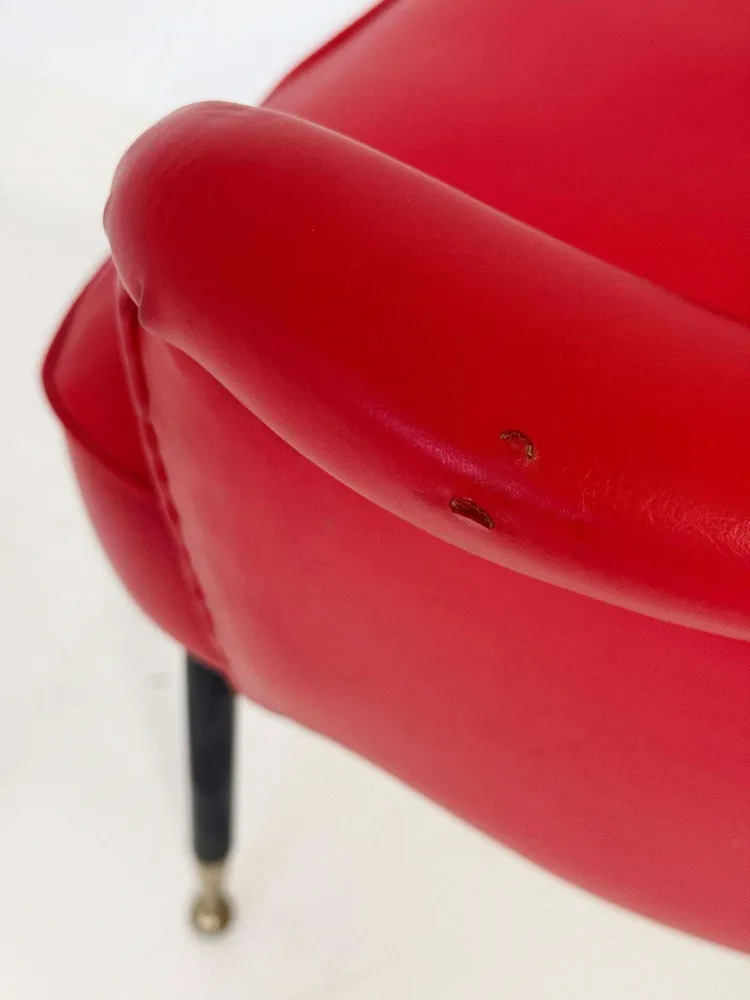 Poltrona italiana anni ’50 skai rosso, con schienale sagomato e apertura posteriore.